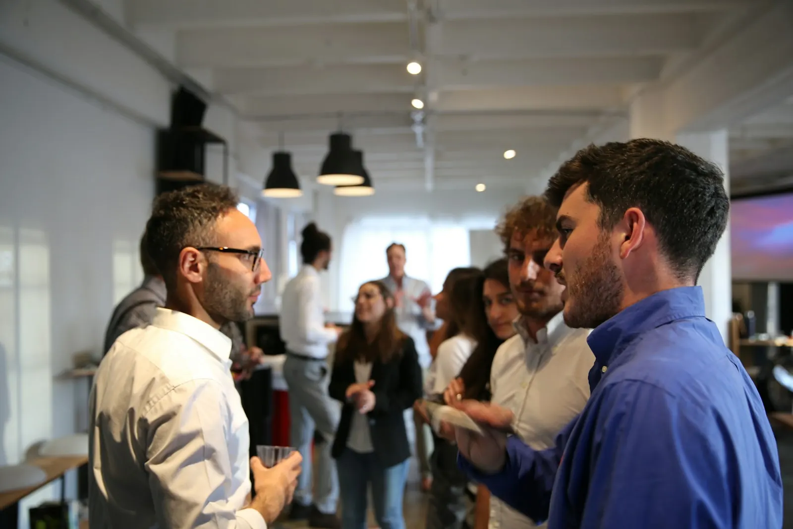 Guests chatting with drinks in a bright indoor event space