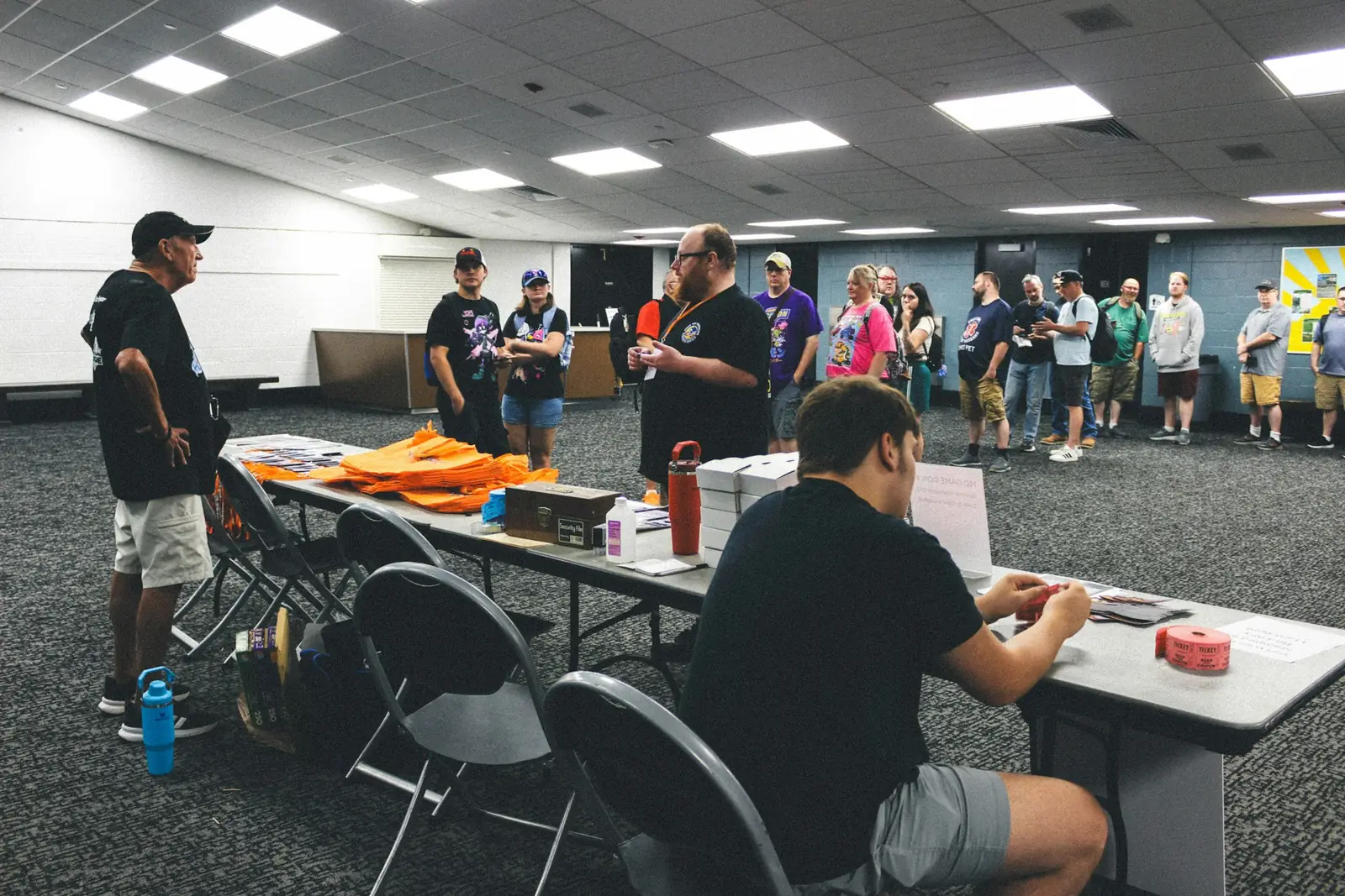 People gathered at registration tables in a large event room