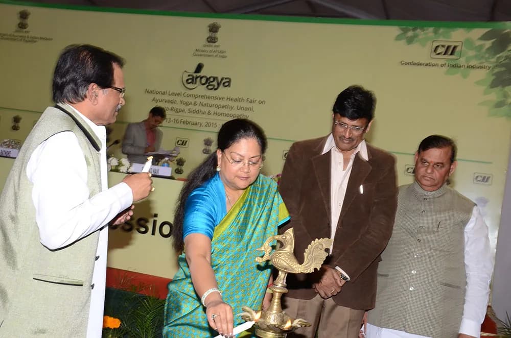 Dignitaries lighting a ceremonial lamp on stage at an inaugural session