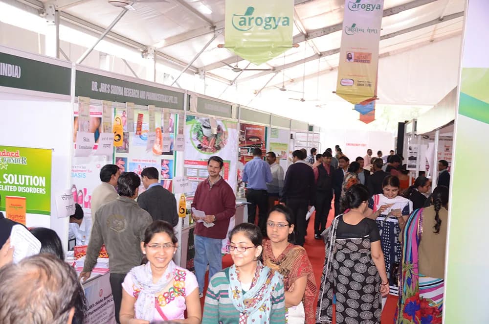 Visitors walking between exhibition stalls in a busy expo hall