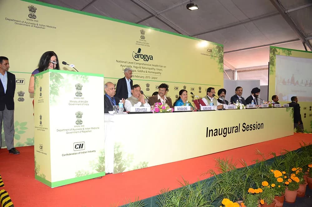 Inaugural session stage with a branded backdrop, podium and seated dignitaries