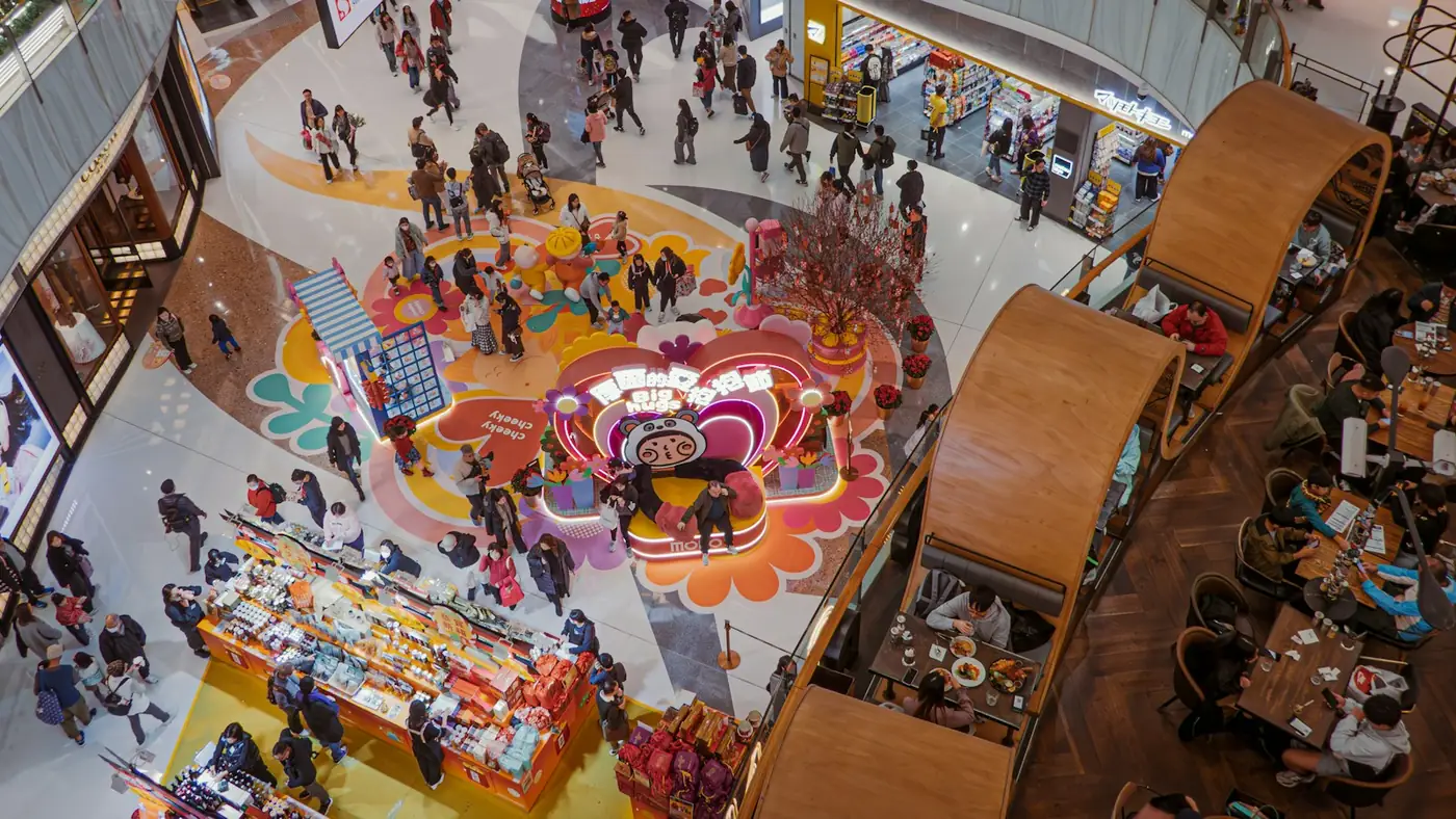 Busy shopping mall floor with colourful decoration and crowds